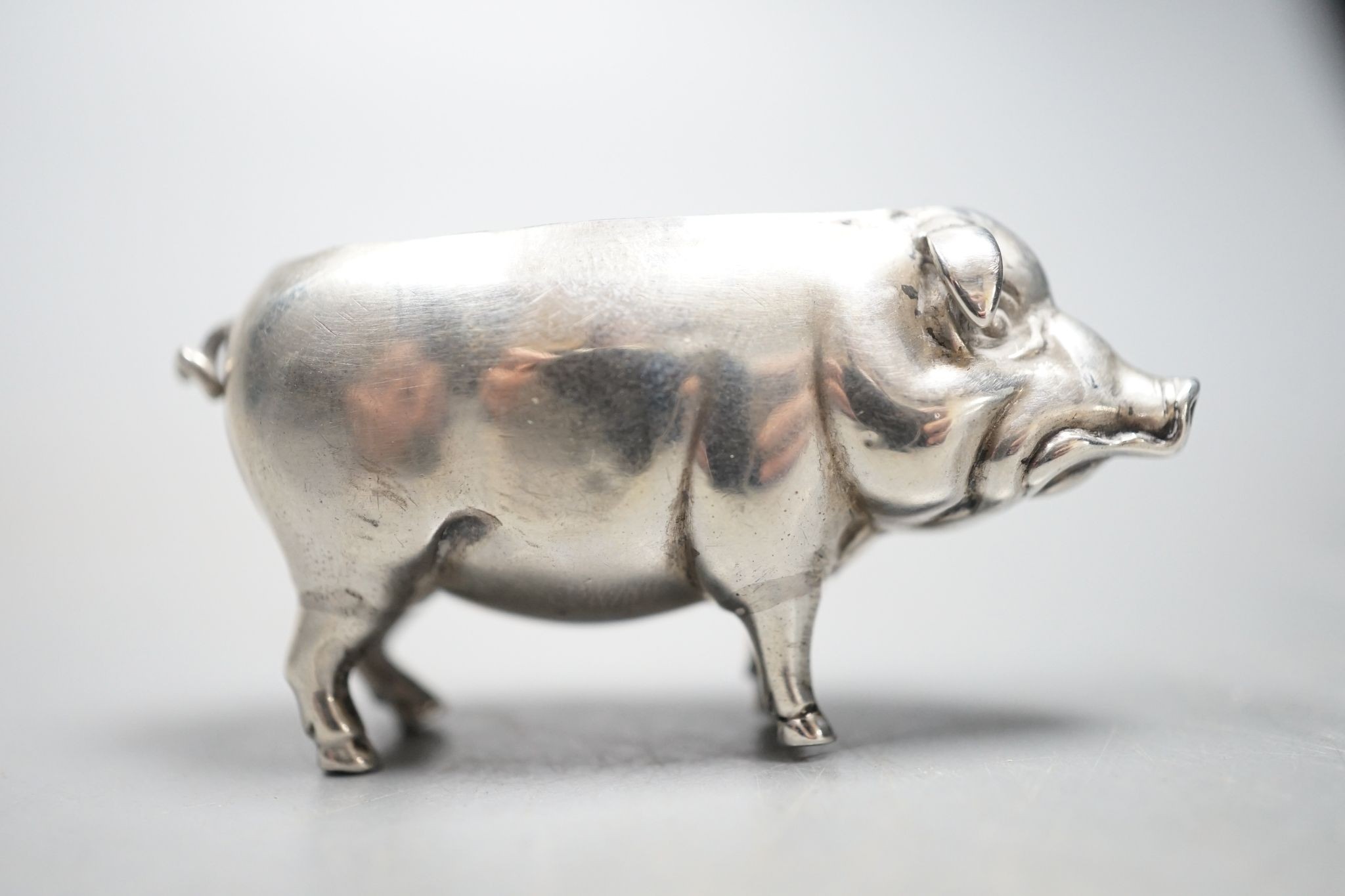 An Edwardian silver pig pin cushion, (lacking cushion), Adie & Lovekin Ltd, Birmingham, 1905, length 49mm.